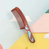 Wooden comb with whale design on a colorful background